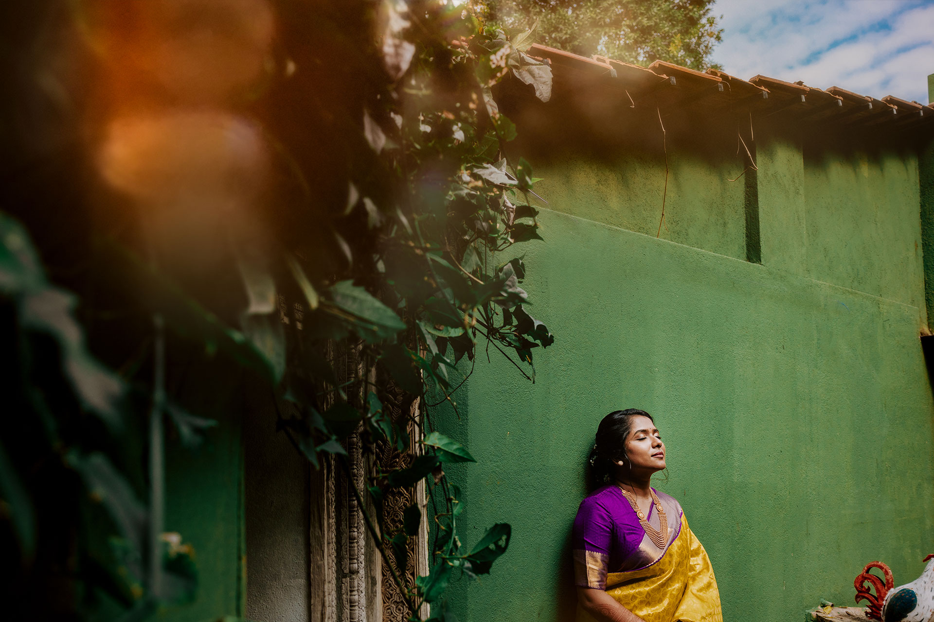 Bride standing in front of a green wall